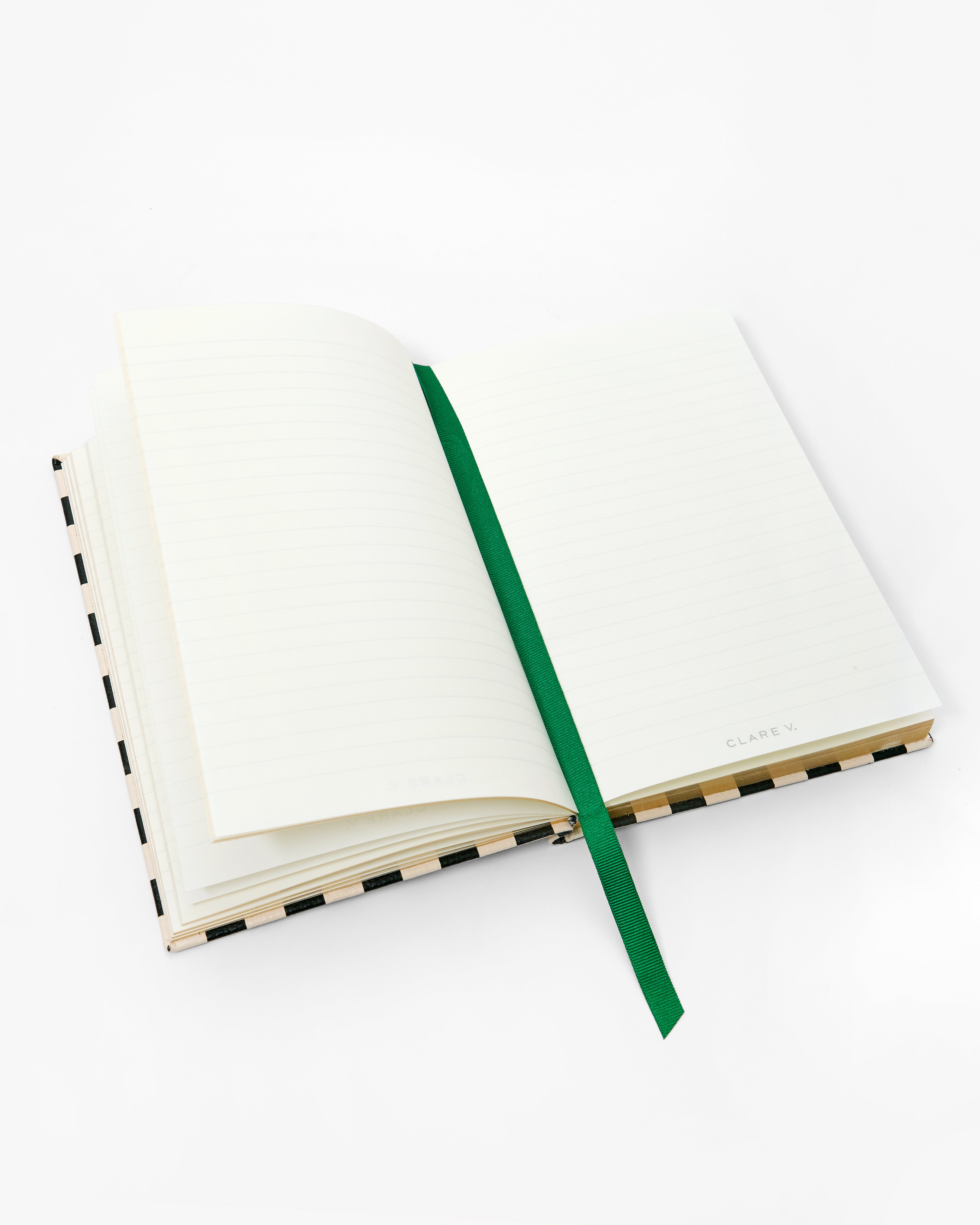 Open notebook with emerald ribbon bookmark in the middle. 