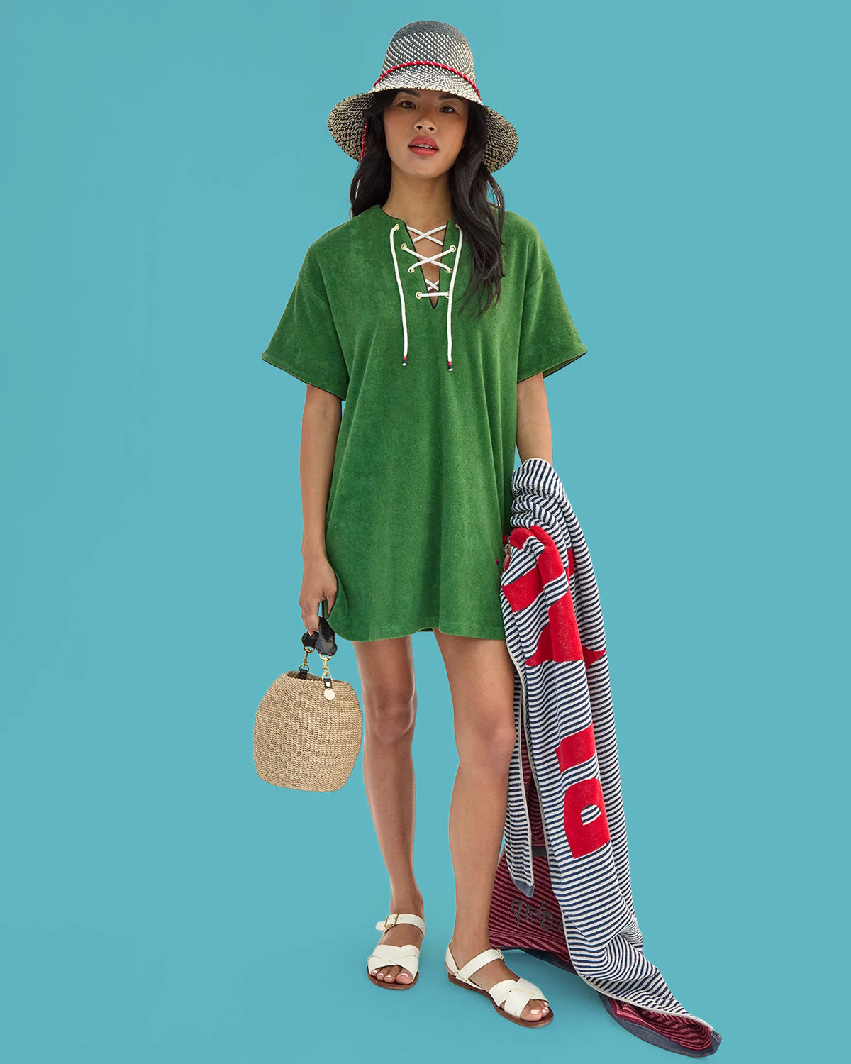 Model wearing La Plage Dress and Romy Hat while carrying Le Towel and Cream Pot de Miel.